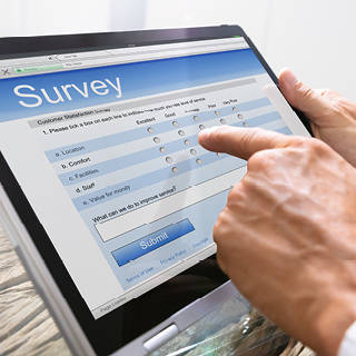 Close up of hands taking survey on tablet